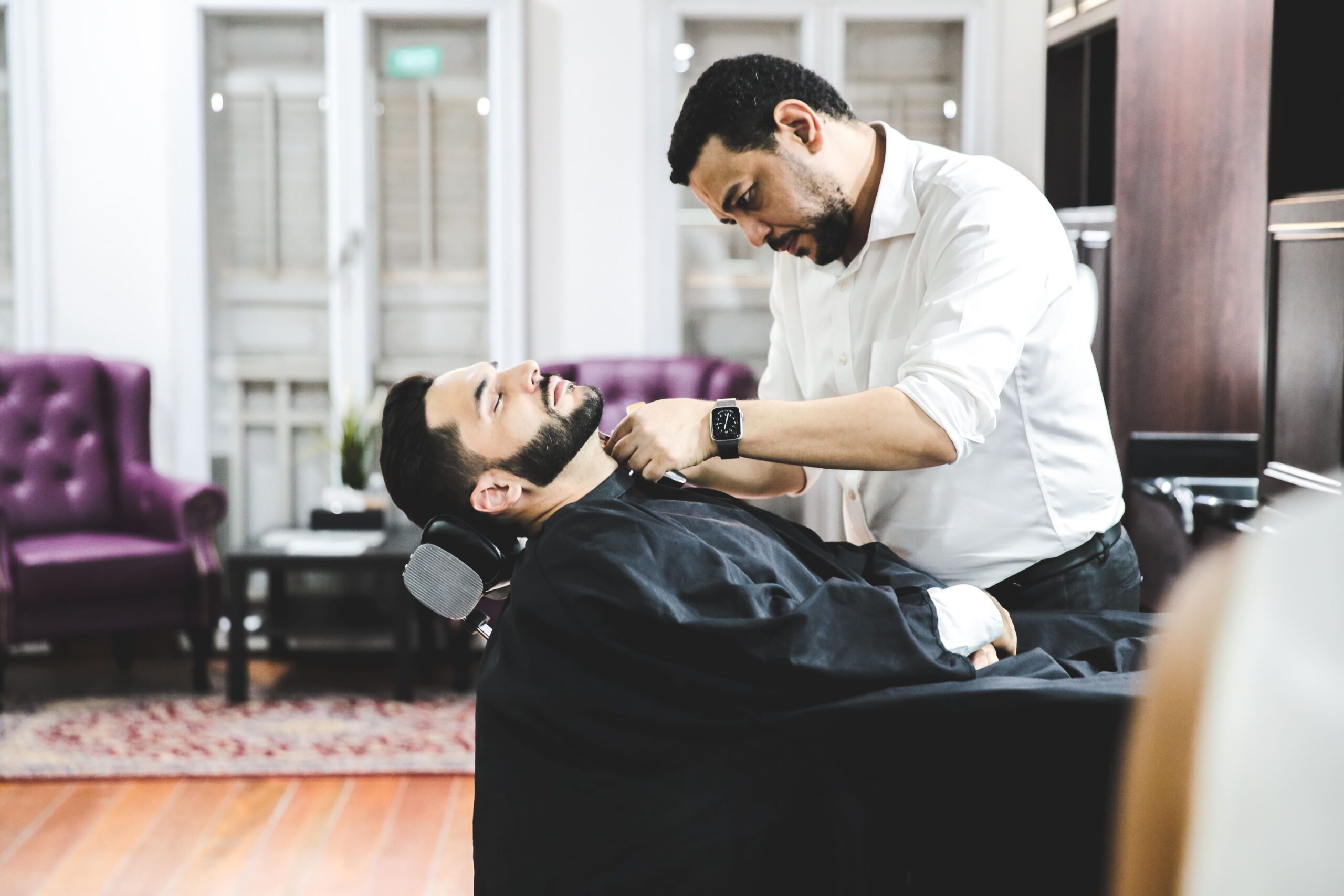 Barber performing precision straight-razor beard shave at The British Barbers premium barbershop in Chinatown Singapore – best gentleman grooming experience