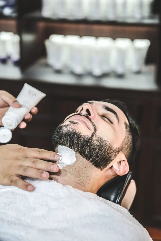 Master barber applying pre-shave cream for traditional hot towel straight-razor shave at The British Barbers premium barbershop in Chinatown Singapore – best gentleman grooming experience