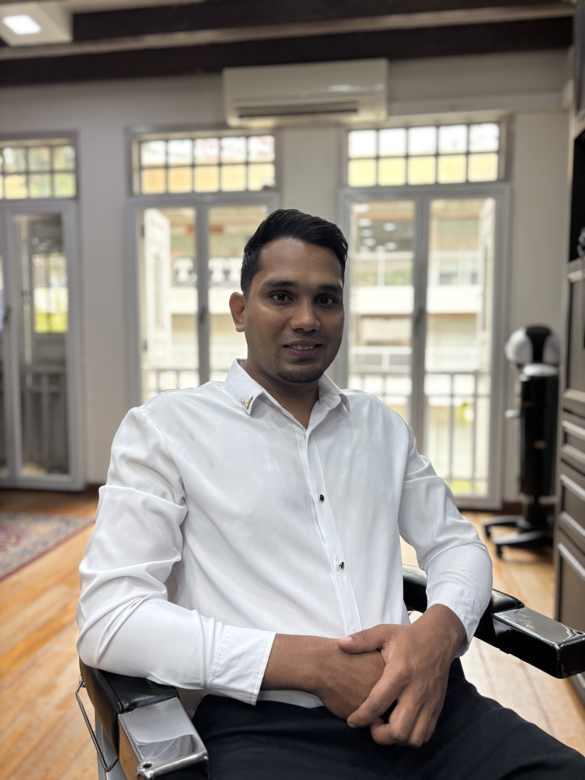 Senior barber Daniel Moses at The British Barbers Chinatown Singapore providing professional men's haircut services