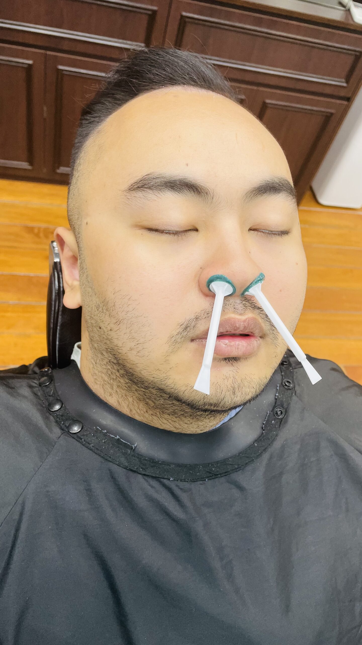 Men's facial waxing Singapore — nose waxing in progress with custom ENT-designed applicator at The British Barbers Chinatown